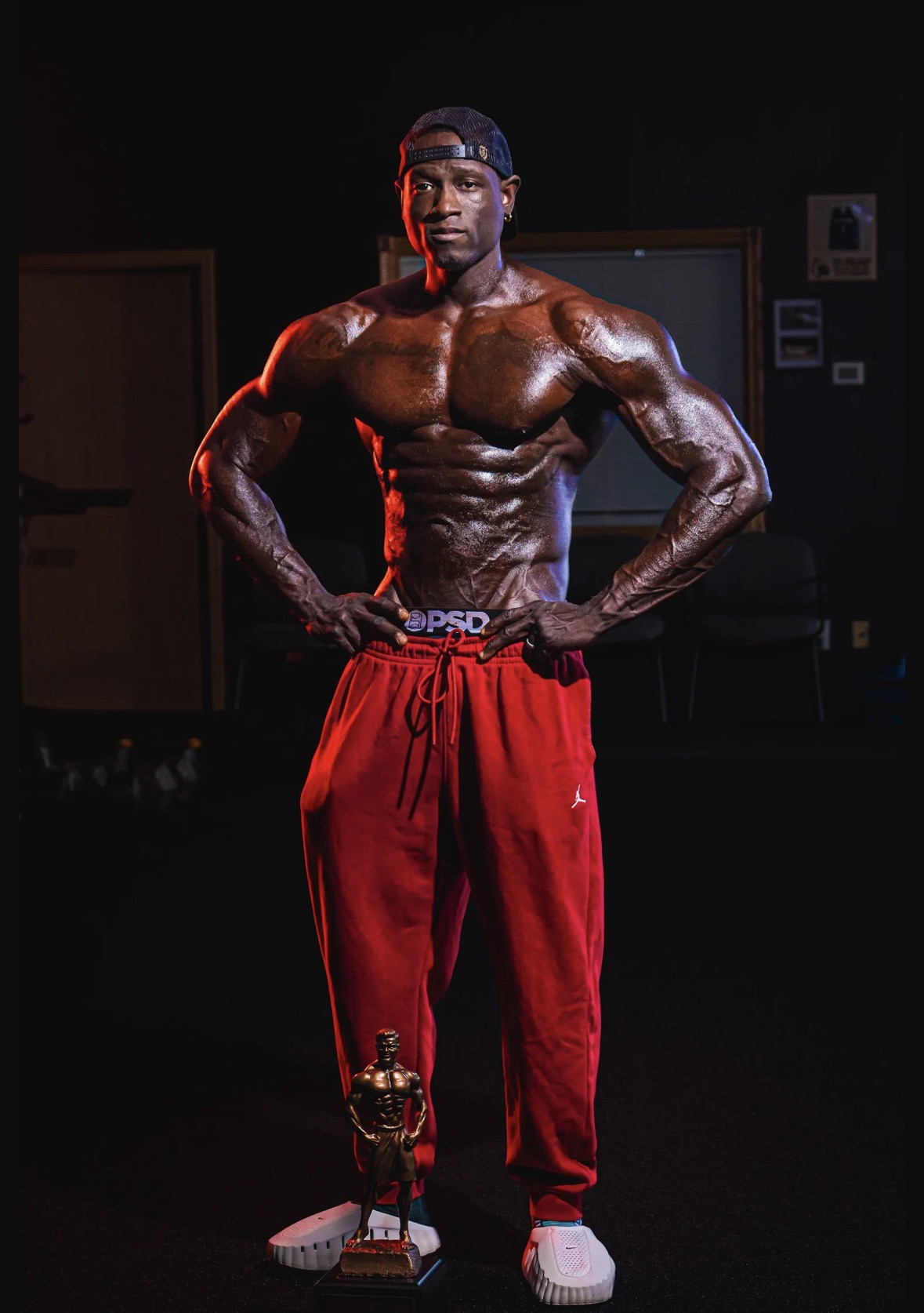 Lawrence Gordon standing with the 2026 NPC Missouri State overall trophy at his feet